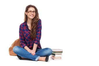 student sitting next to books